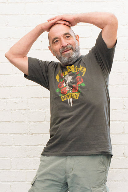 model wearing black cotton t-shirt with guns 'n' roses nightrain skull and roses graphic print on front
